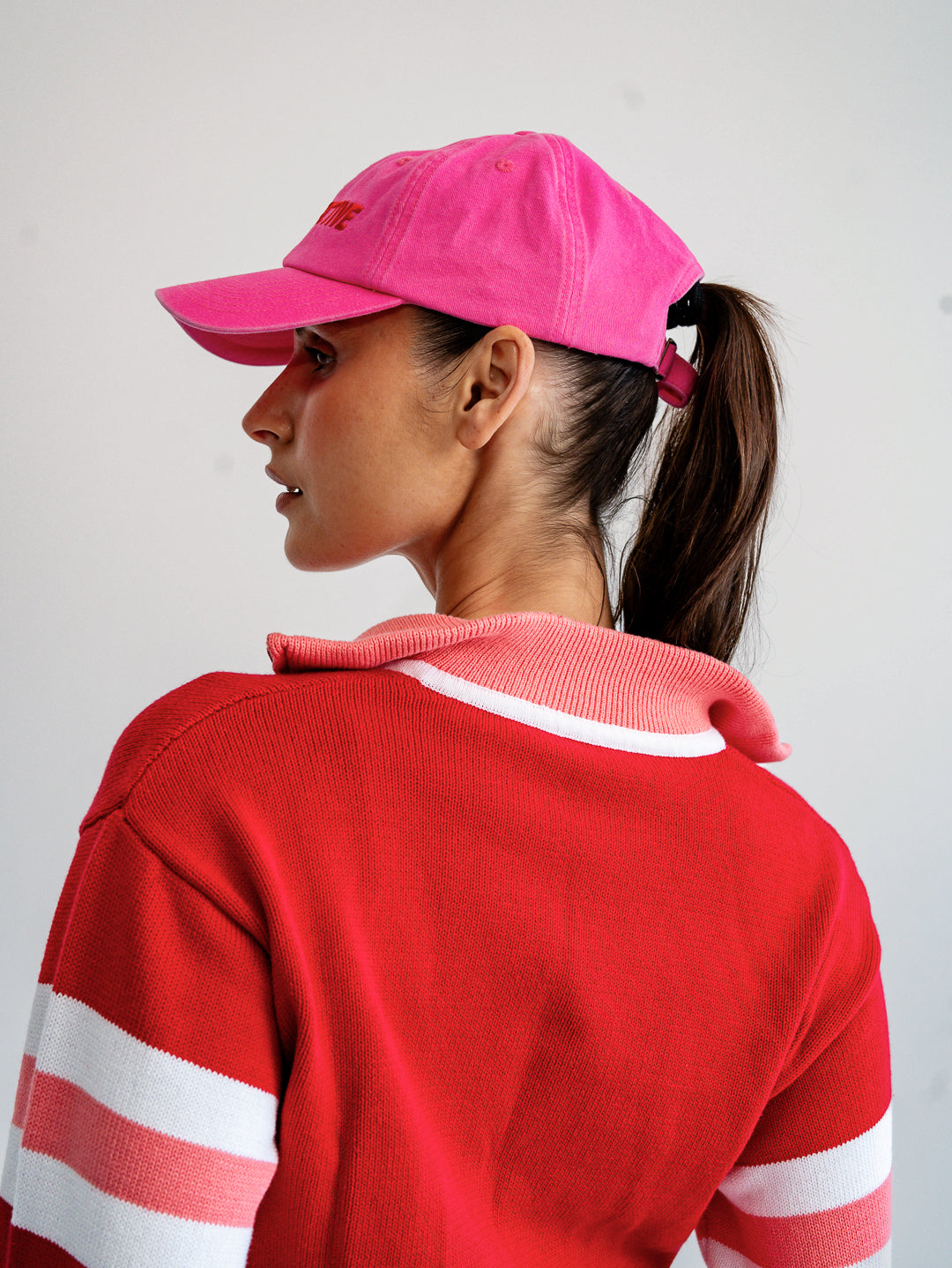 Side profile of fuchsia pink and red cap