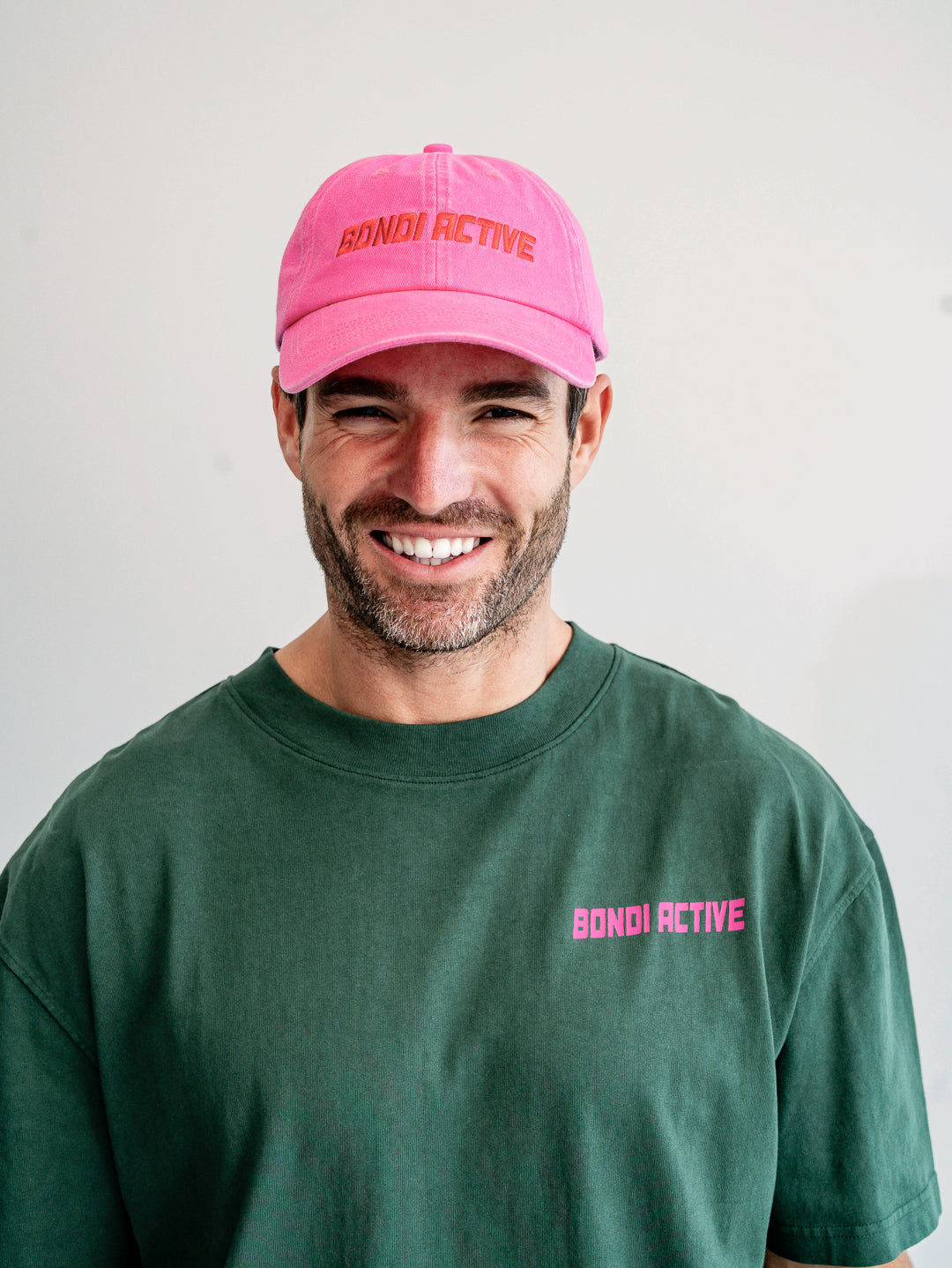 Close-up of fuchsia pink and red cap logo