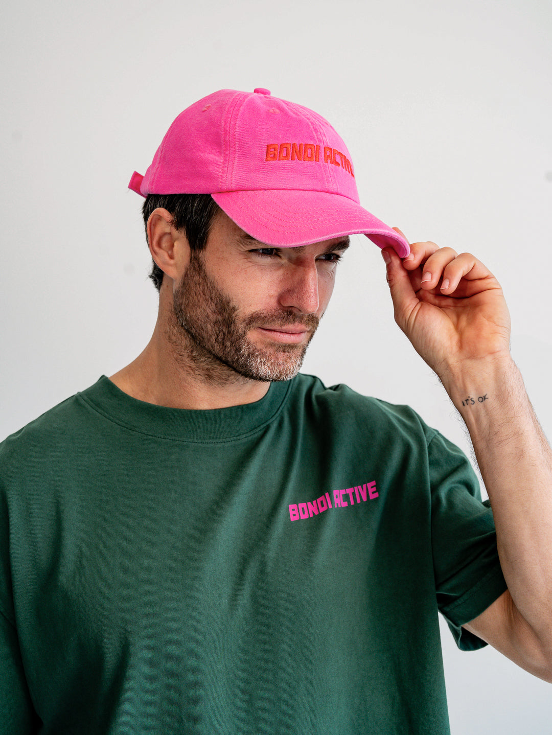 Side profile of fuchsia pink and red cap on model