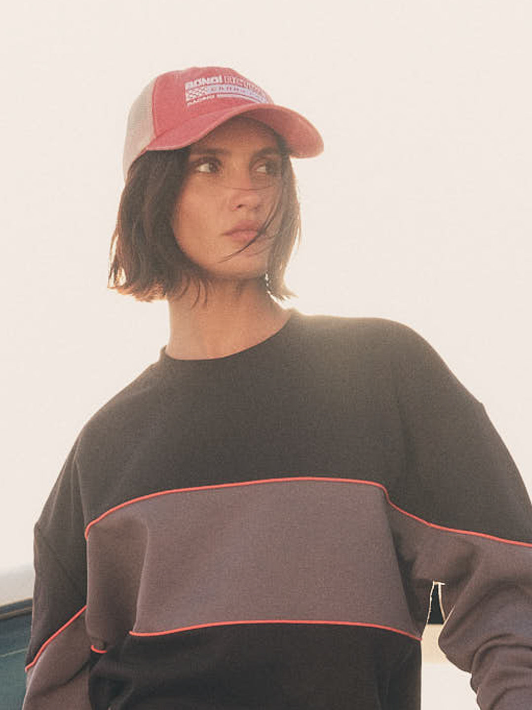 Model wearing washed red and white cap outdoors
