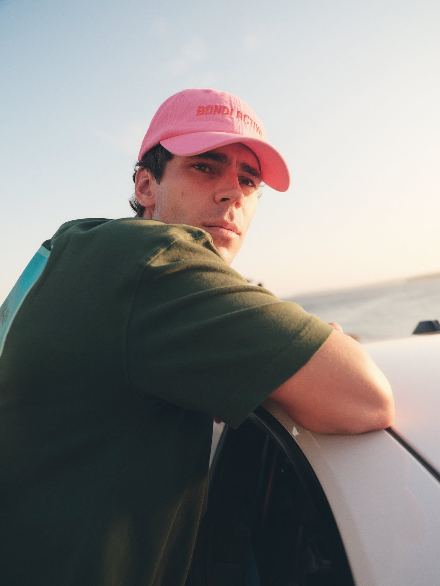 Model wearing fuchsia pink and red cap