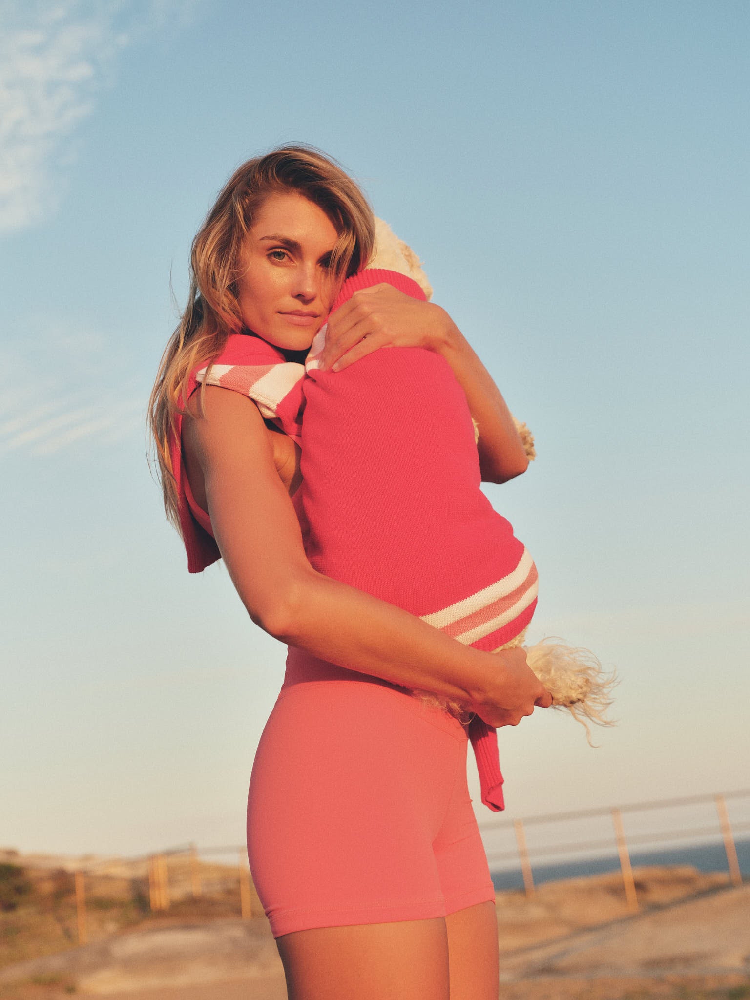Side profile of model wearing bright coral 3.5" bike short