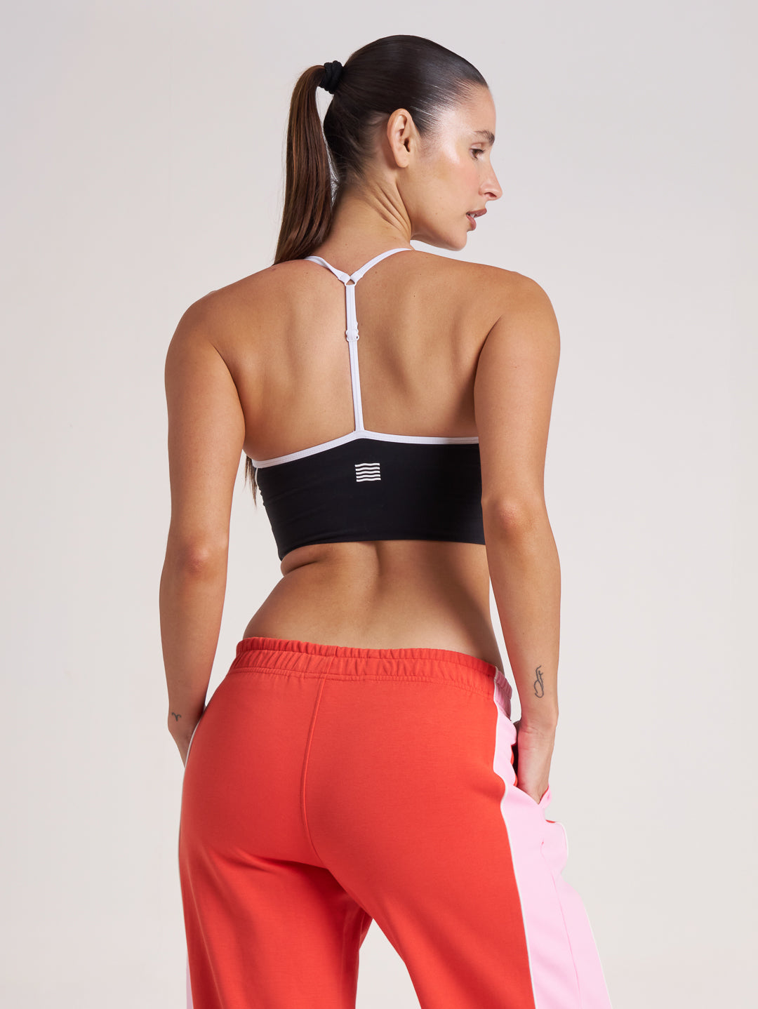 Back view of black and white sports bra crop on model