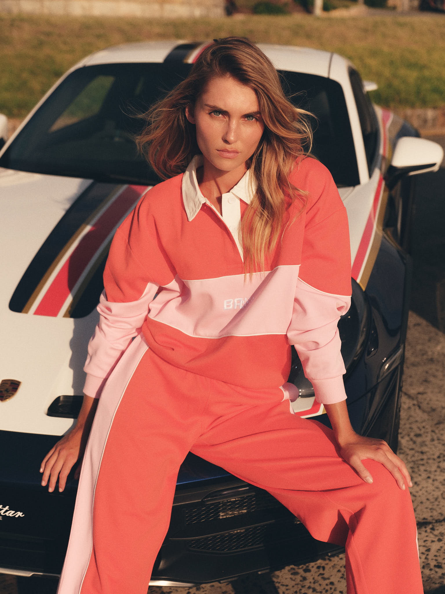 Model in motion wearing tomato red and pink wide leg pant